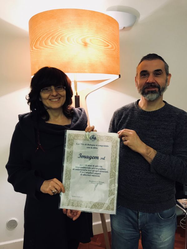 Paola Samoggia e Carlo Magrì della ditta Imagem srl con la pergamena "Buon Anniversario" per i 10 anni di attività dell'azienda