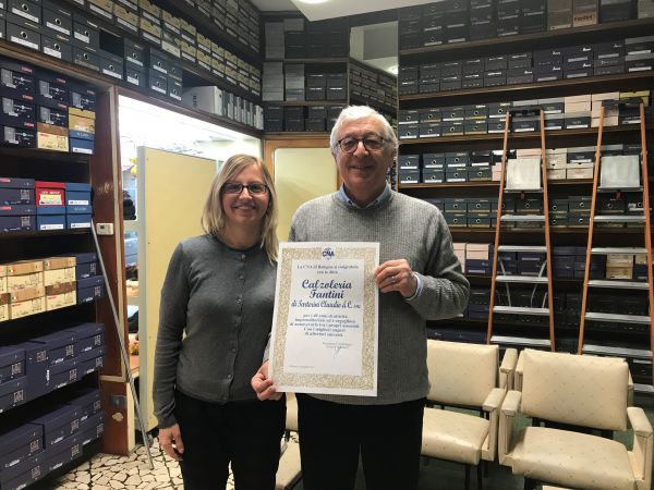 Francesca Tarterini di Cna Bologna e Claudio Tarterini della ditta Calzoleria Fantini di Tarterini Claudio & C snc, con la pergamena "Buon Anniversario" per i 40 anni di attività dell'azienda