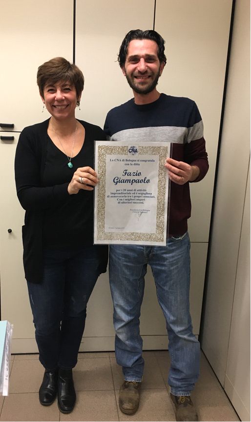 Paola Albertini di Cna Bologna e Fazio Giampaolo della ditta omonima, con la pergamena "Buon Anniversario" per i 20 anni di attività dell'azienda